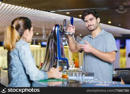 waiter making a drink for a female customer