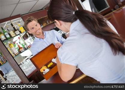 Waiter offering box of teas to customer
