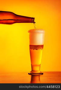 Waiter pouring beer, glass of a cold drink isolated on yellow warm background, alcoholic beverage, festival of beer, oktoberfest autumn holiday