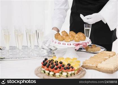 waiter presenting mix food drinks table