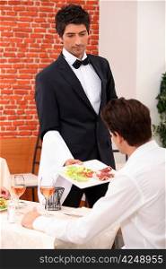 Waiter serving a meal in a restaurant