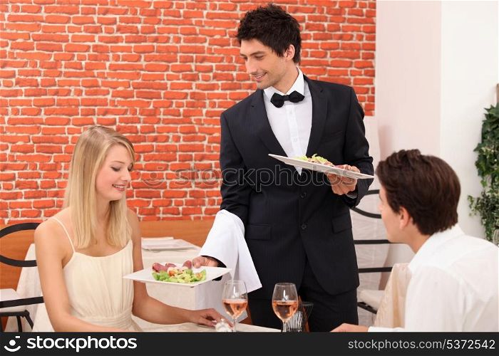 Waiter serving plate of food