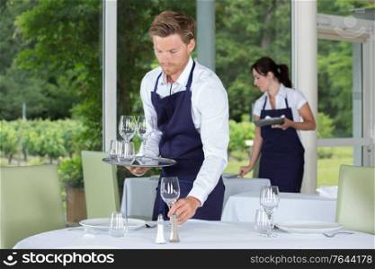 waiter setting the table in a fancy restaurant
