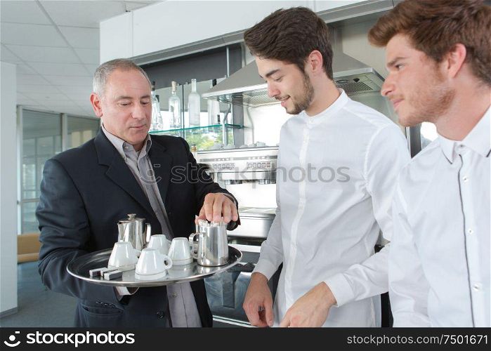 waiters preparing to serve tray of tea