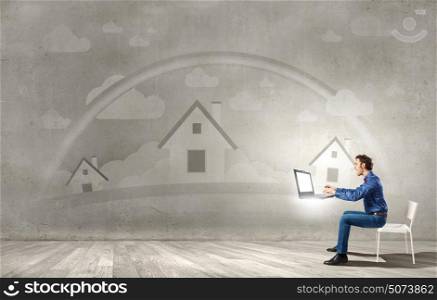 Waiting for inspiration!. Young man sitting in chair and using laptop
