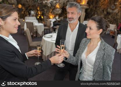 Waitress giving couple a glass of champagne