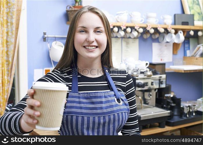 Waitress In Cafe Serving Customer With Takeaway Coffee