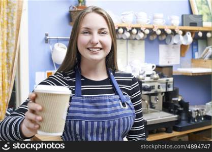 Waitress In Cafe Serving Customer With Takeaway Coffee