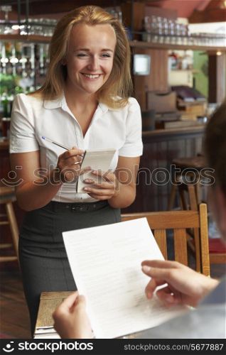 Waitress In Restaurant Taking Order From Customer