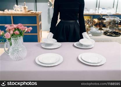 Waitress puts the dishes for banquet, table setting. Serving service, festive dinner decoration. Waitress puts dishes for banquet, table setting