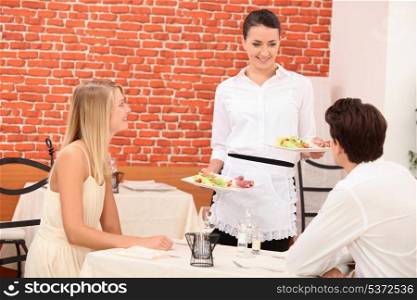 Waitress serving couple