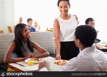 Waitress Serving Couple Breakfast In Hotel Restaurant
