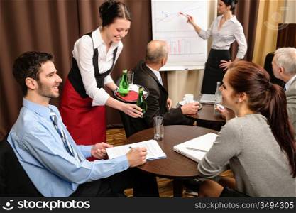 Waitress serving people at business meeting flipchart presentation
