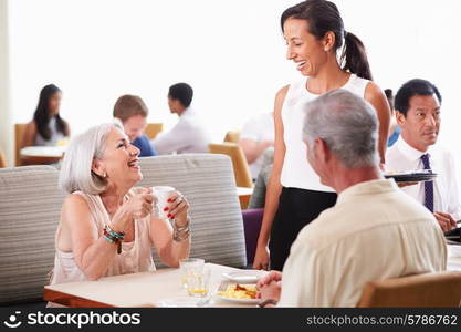 Waitress Serving Senior Couple Breakfast In Hotel Restaurant