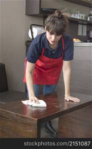waitress wiping table with napkin caf