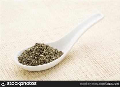 wakame seaweed on a white Chinese spoon against burlap canvas