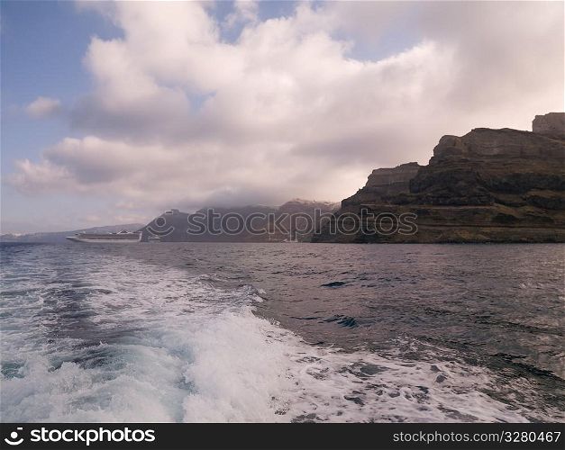 Wake of ship along Santorini shoreline