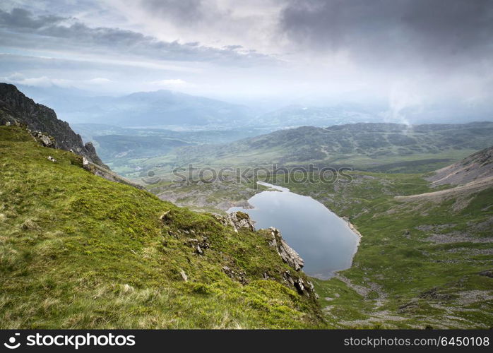 Wales, Gwynedd, Snowdonia . Looking from top of Cadair Idris mountain in Snowdonia National Park over Llyn y Gader with cloudy stormy sky.. Looking from top of Cadair Idris mountain in Snowdonia National Park over Llyn y Gader with cloudy stormy sky.