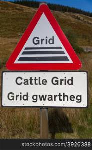 Wales, United Kingdom triangular road warning signs, plates in English and welsh. Cattle grid.