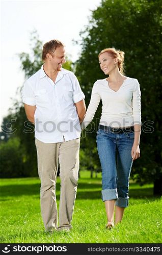 Walk of a cheerful couple in a summer garden