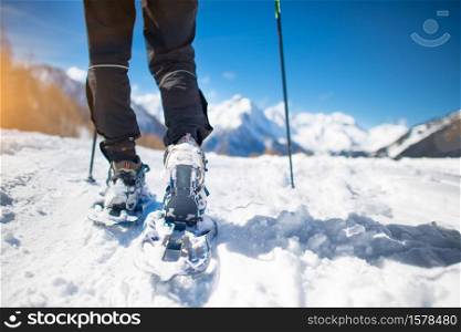 Walk with snowshoes in the snow during mountain holidays.