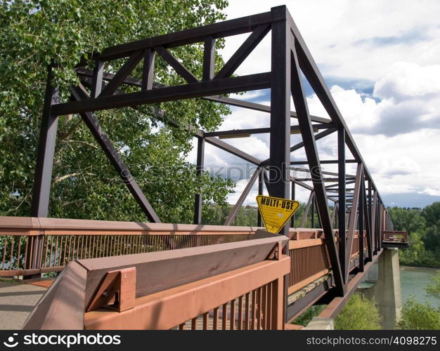 Walking bridge carossing a river at the apex of summer.