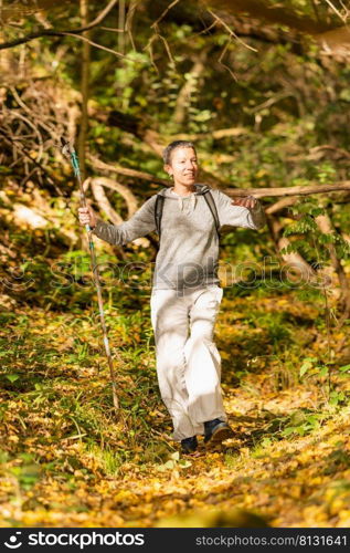 Walking mindfulness. Mindful middle-aged woman walking through the autumn forest. . Walking mindfulness