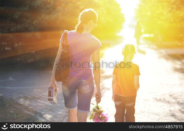 walking on sunrise. Blurred photo of walking woman with her son on sunrise