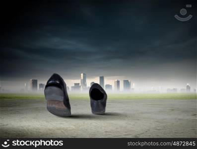 Walking shoes. Pair of black shoes walking on road