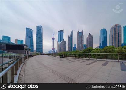Walkway in Shanghai Downtown, China. Financial district and business centers in smart city in Asia. Skyscraper and high-rise office buildings at sunset.