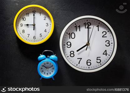 wall and alarm clock at black background texture