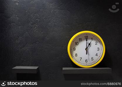 wall clock at shelf on black background texture