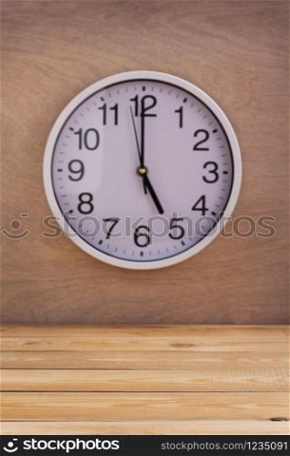 wall clock at wall near wooden table background texture