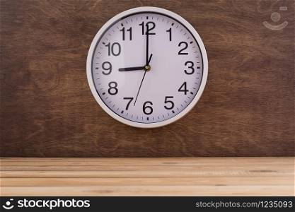 wall clock at wall near wooden table background texture