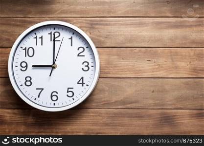 wall clock at wooden background texture