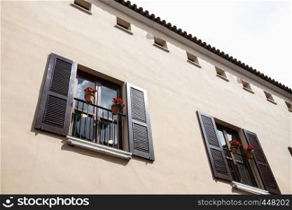 wall facade with two wooden balconies and flower pots