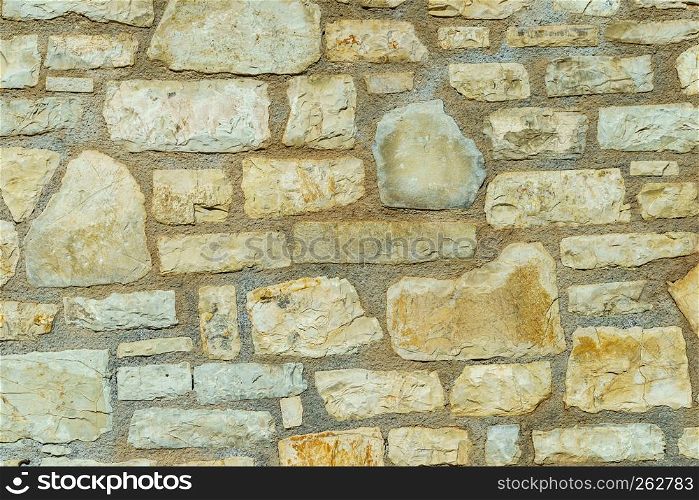 Wall made of stone bricks. Texture, background in the ancient style. Architectural details of Greece.. Wall made of stone bricks.