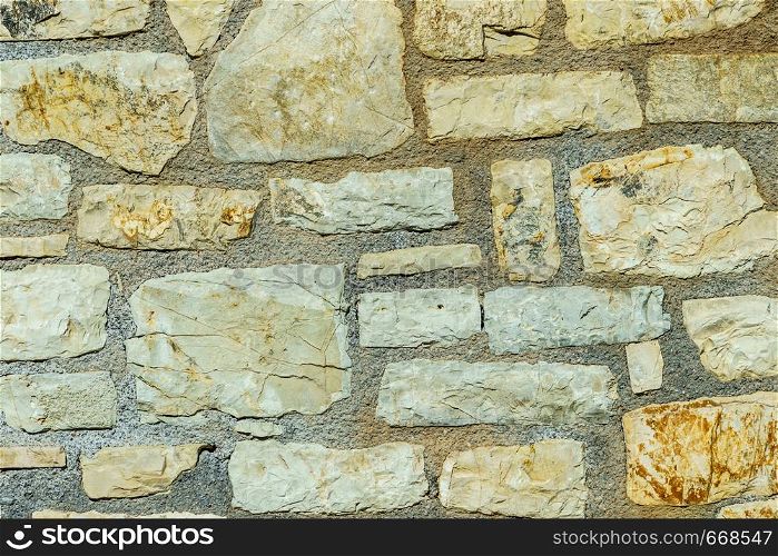 Wall made of stone bricks. Texture, background in the ancient style. Architectural details of Greece.. Wall made of stone bricks.