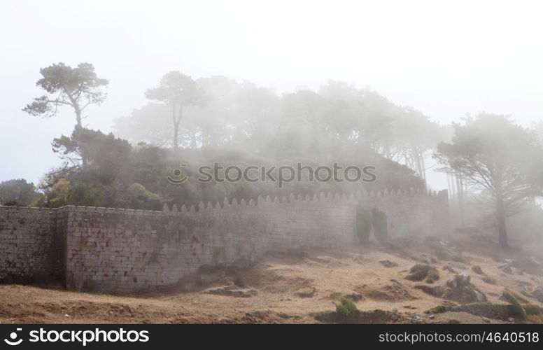 Wall of a fortress on the hillside covered fog