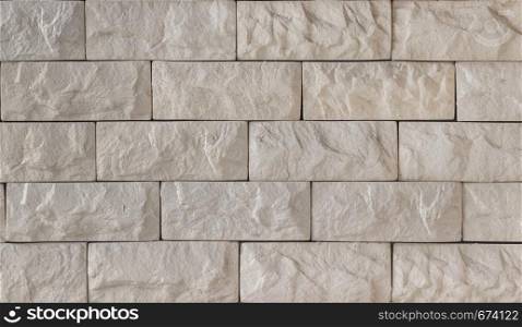 Wall of beige decorative brick close-up as background or texture.