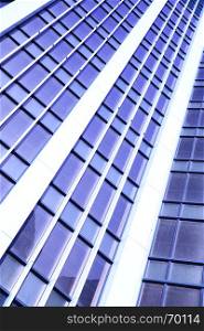 Wall of office building close-up. Toned in blue color