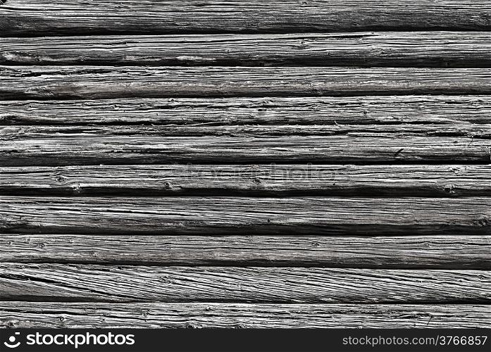 Wall of old weathered logs with cracks, black and white