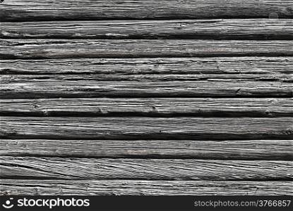 Wall of old weathered logs with cracks, black and white