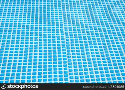 Wall of swimming pool with water of blue color