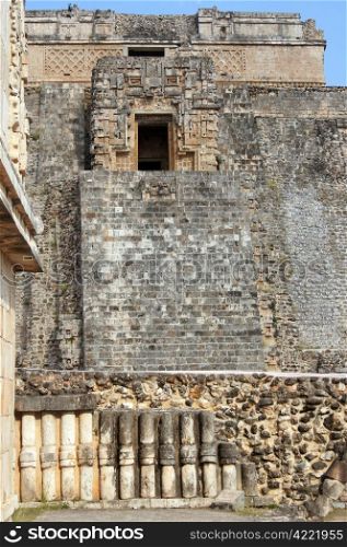 Wall of temple and pyramid in Uxmal, Mexico