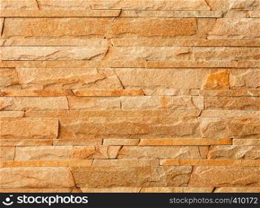 Wall stone mosaic made of golden sandstone texture. Stone mosaic made of sandstone texture