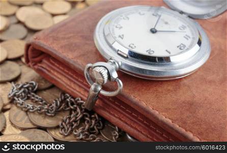 Wallet and pocket watch on the coins background