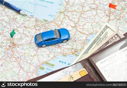 wallet, pen and blue car on the map of Europe