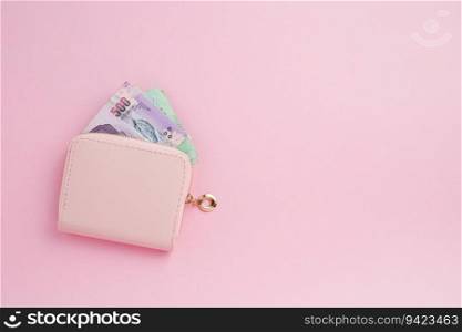 Wallet with Thai currency banknote on pink background for business, finance, investment and saving money concept