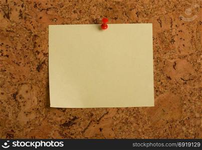 wallpaper from a cork tree on which a red button is pinned an empty yellow paper